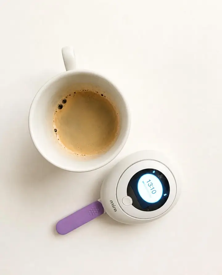 Mira-Tracker neben einer Tasse Kaffee